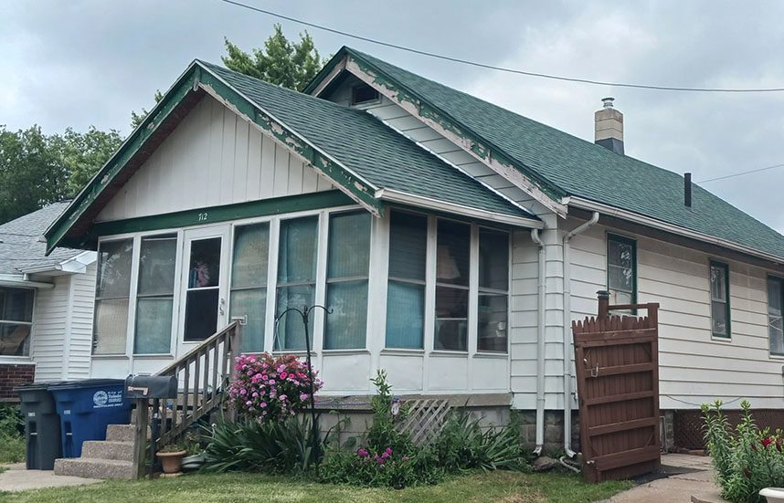 House in need of a new roof in a middle class Midwest neighborhood.